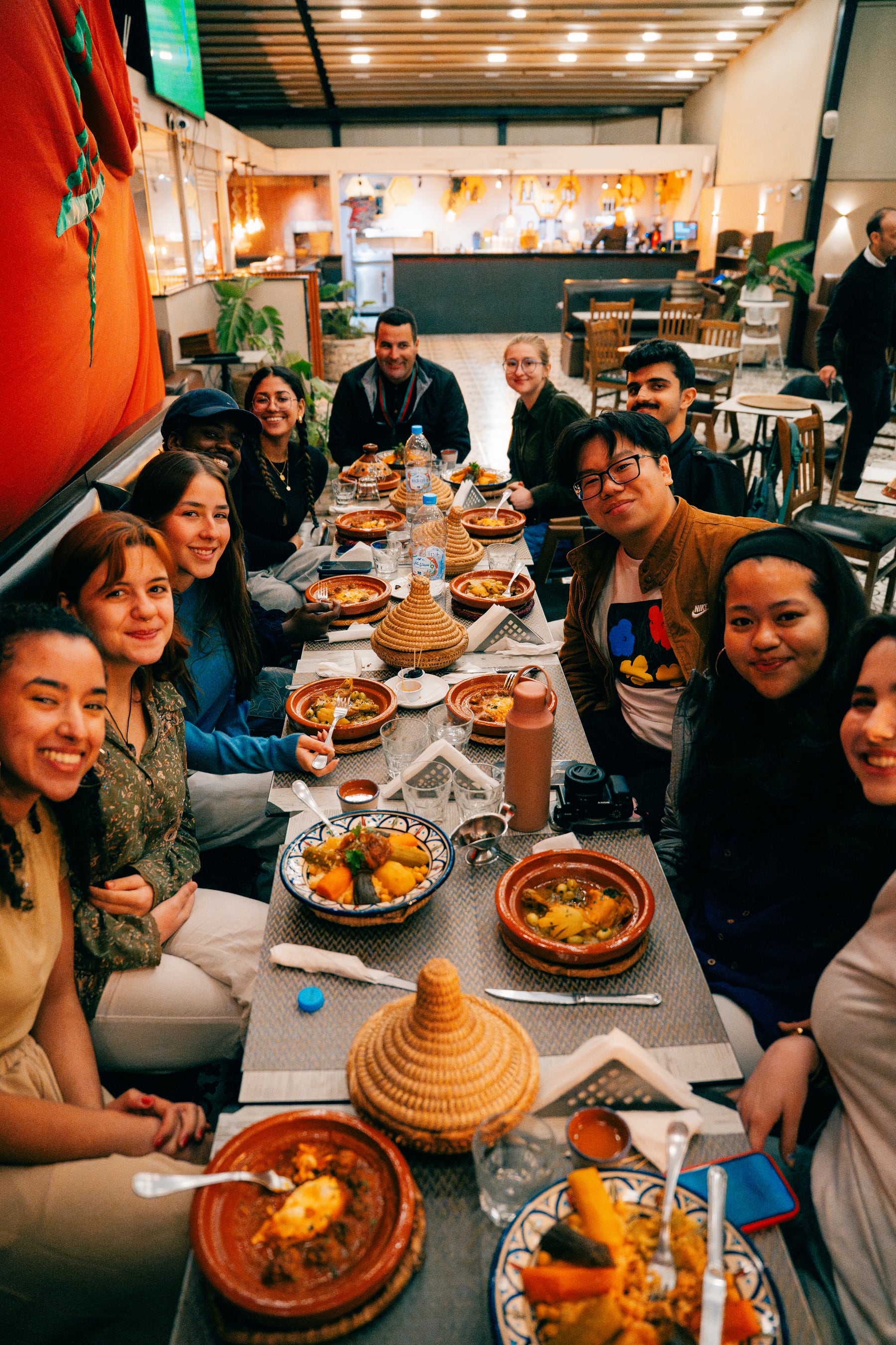 Tende and friends sharing a meal around a long table